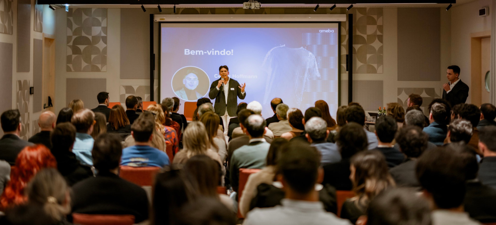 Speaking on stage to a full room at an Ameba event in Portugal